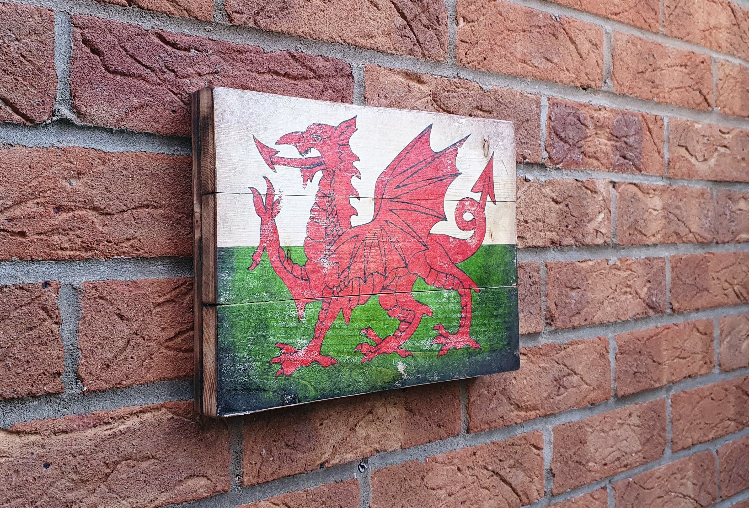 Wales flag on the rustic wood with burnt edges